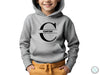 a young boy wearing a grey hoodie with the letter c on it