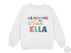 a white sweatshirt with the words learning fun with ella printed on it